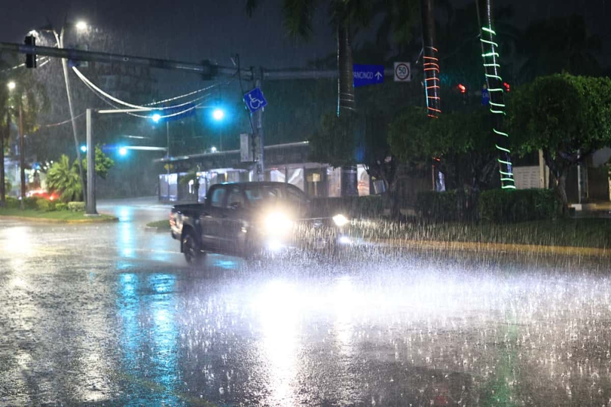 MEX5866. ACAPULCO (MÉXICO), 18/06/2025.- Un auto circula bajo la lluvia este miércoles, en el balneario de Acapulco en Guerrero (México). El huracán Erick alcanzó la categoría 3 y se dirige hacia las costas de Oaxaca y Guerrero, en el sur de México, donde podría tocar tierra durante la madrugada del jueves con mayor fuerza, según el Servicio Meteorológico Nacional (SMN), que advirtió sobre su rápida intensificación y la posibilidad de que suba a categoría 4 en las próximas horas. EFE/ David Guzmán
