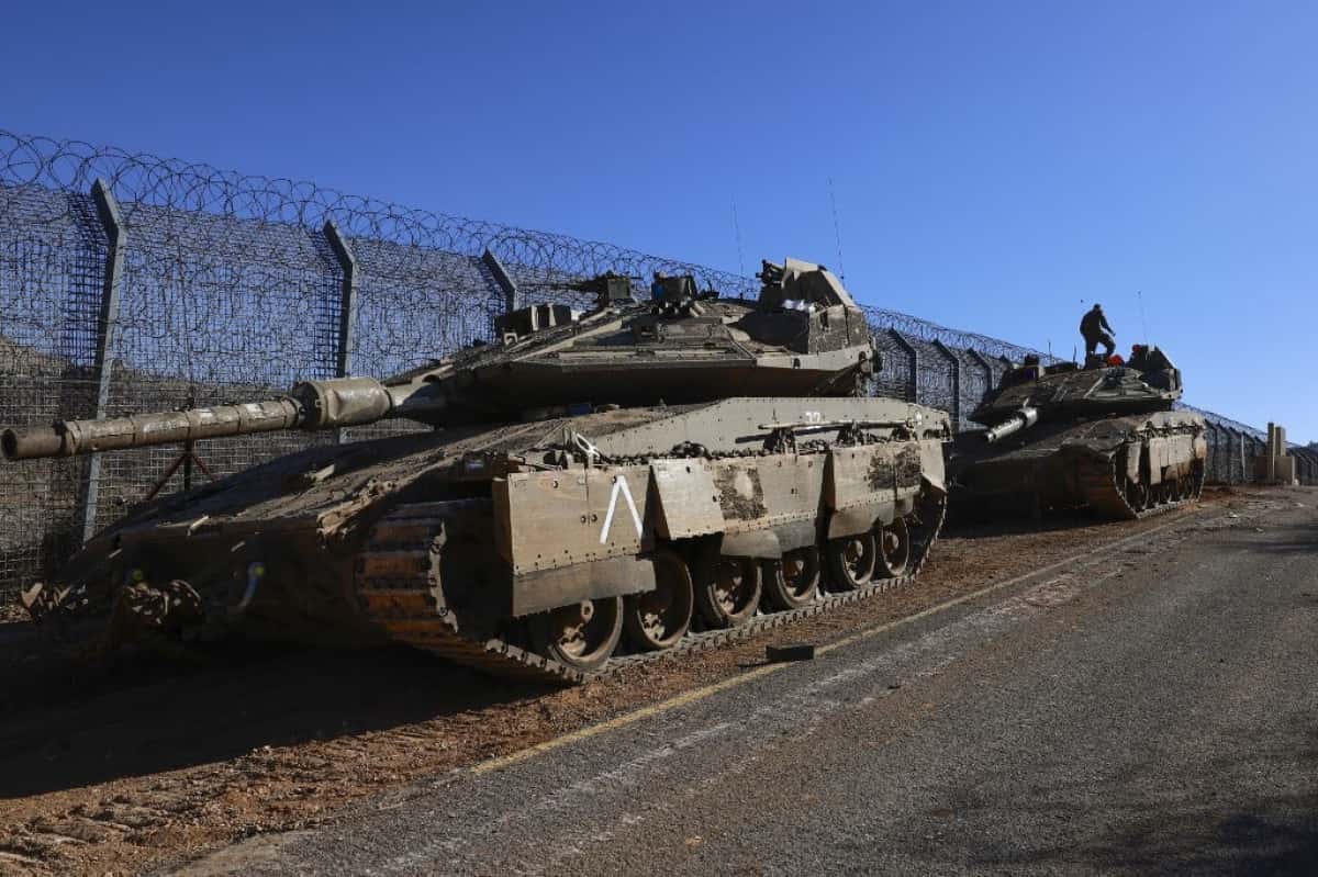 Israeli troops deploy at the buffer zone that separates the Israeli-annexed Golan Heights from Syria, on December 9, 2024, near the Druze village of Majdal Shams. Israel's Foreign Minister Gideon Saar said on December 9 that his country's military takeover of the buffer zone along its border with Syria was a "limited and temporary step" after Prime Minister Benjamin Netanyahu announced the previous day that he had ordered the army to "take control" of the zone, following the fall of Syrian president Bashar al-Assad. (Photo by Menahem Kahana / AFP)