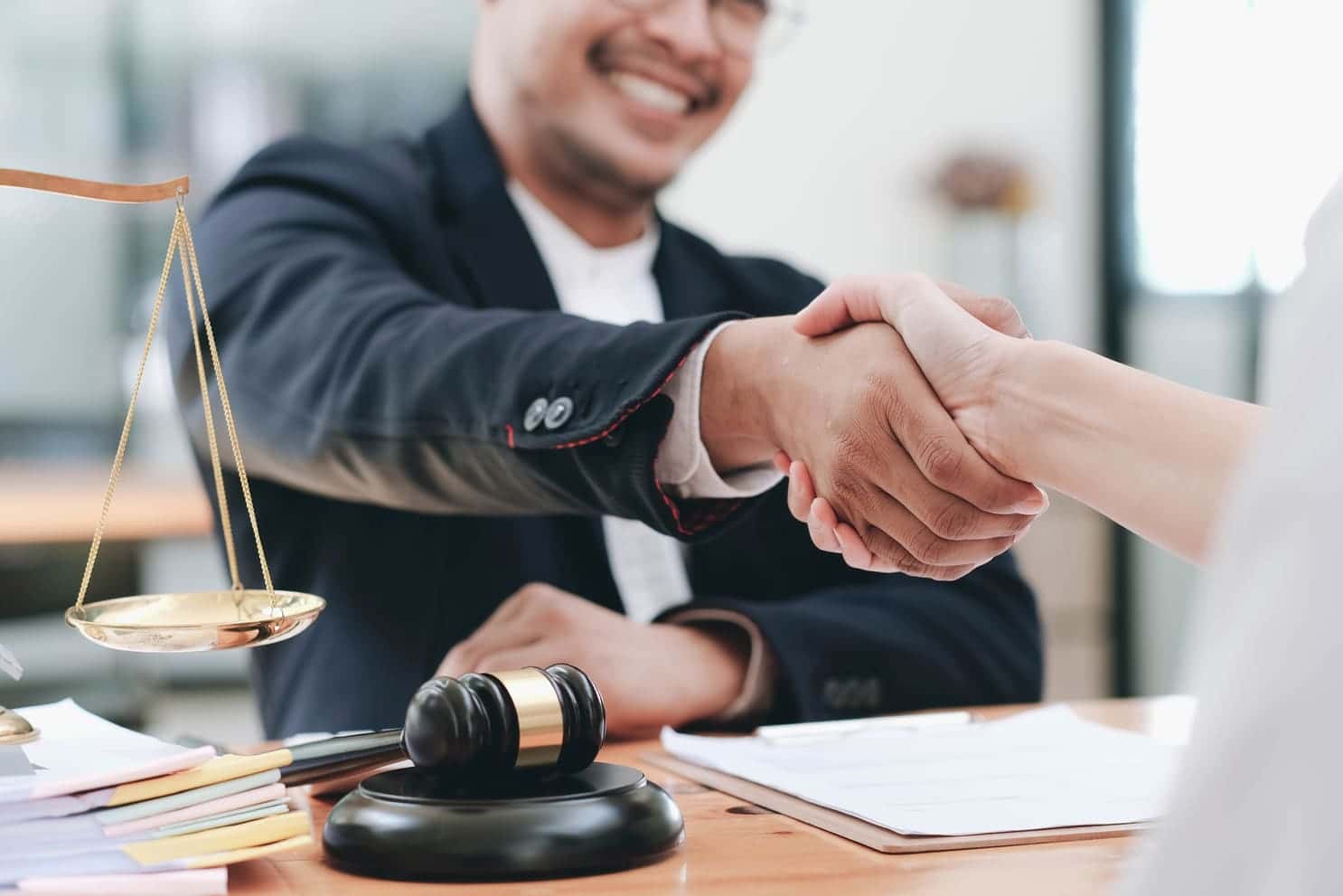 Businessman shaking hands to seal a deal with his partner lawyers or attorneys discussing a contract agreement.
