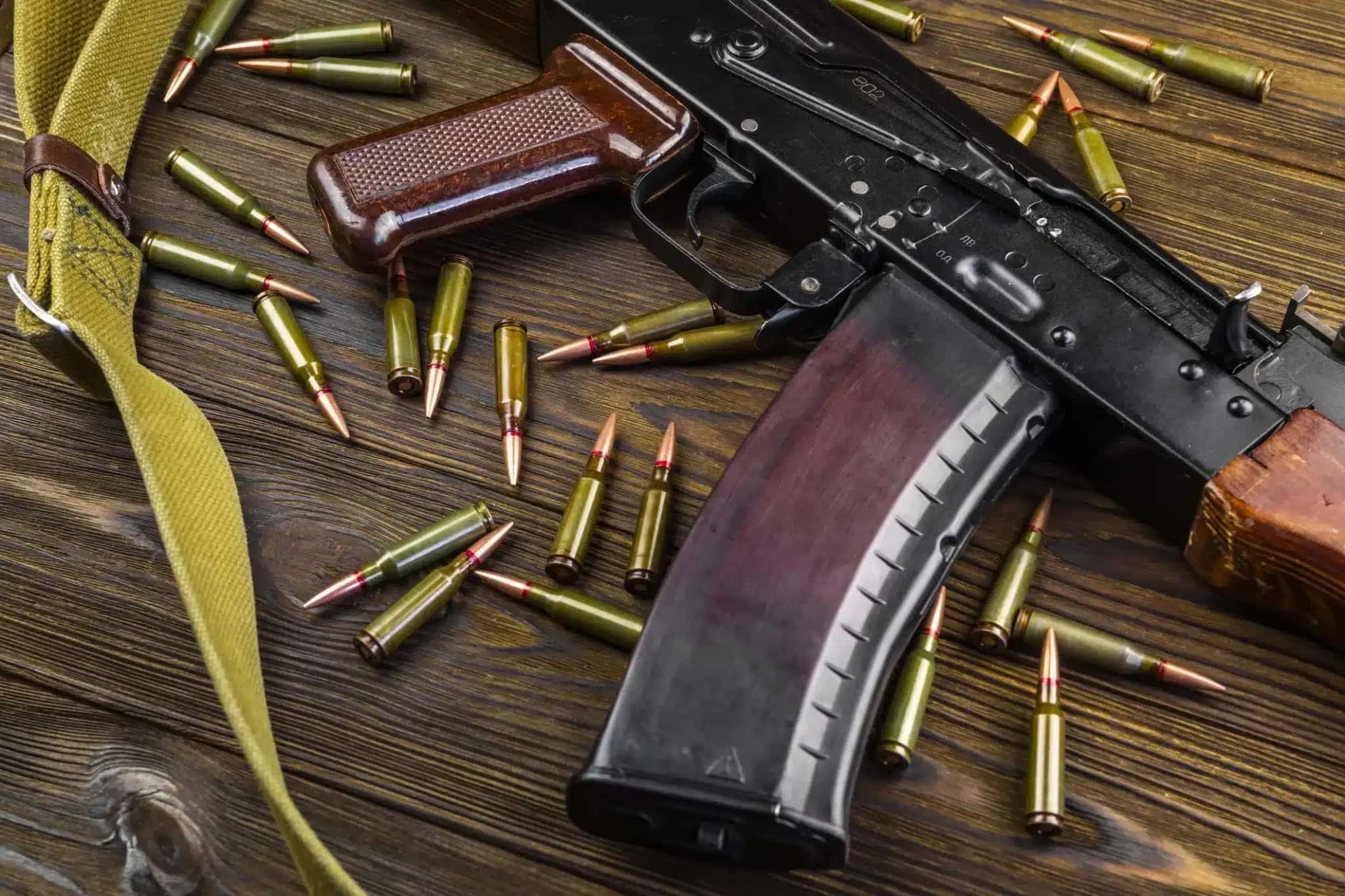 Fuzil Ak-47 com balas em cima de mesa