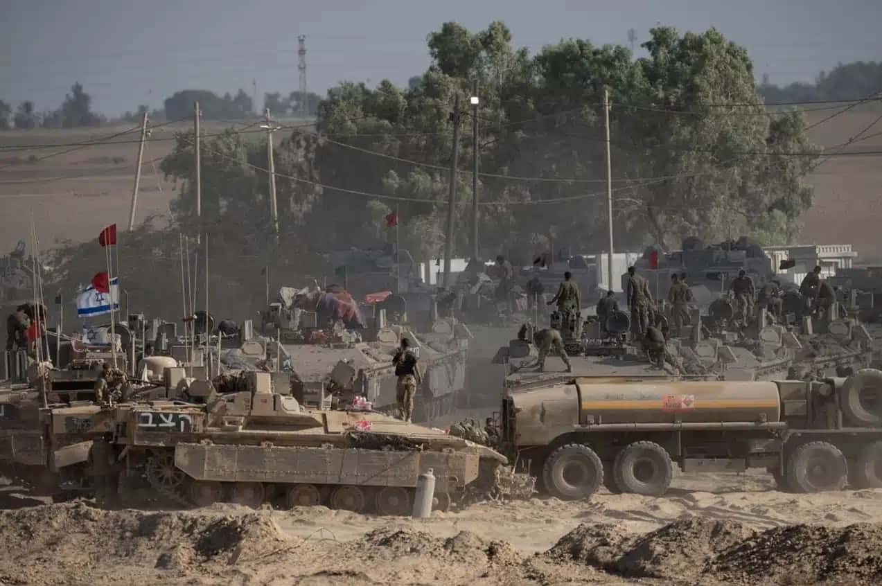 Soldados israelenses organizam equipamentos militares em veículos blindados perto da fronteira com Gaza, no sul de Israel, em 6 de agosto