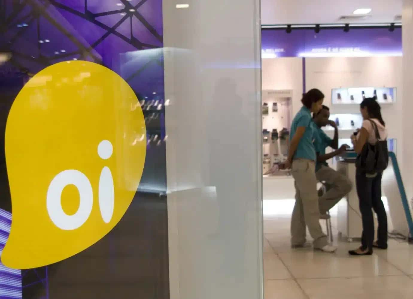 Patrons speak to a representative at an Oi mobile phone store in the Eldorado Mall in Sao Paulo, Brazil. (Photo by Paulo Fridman/Corbis via Getty Images)