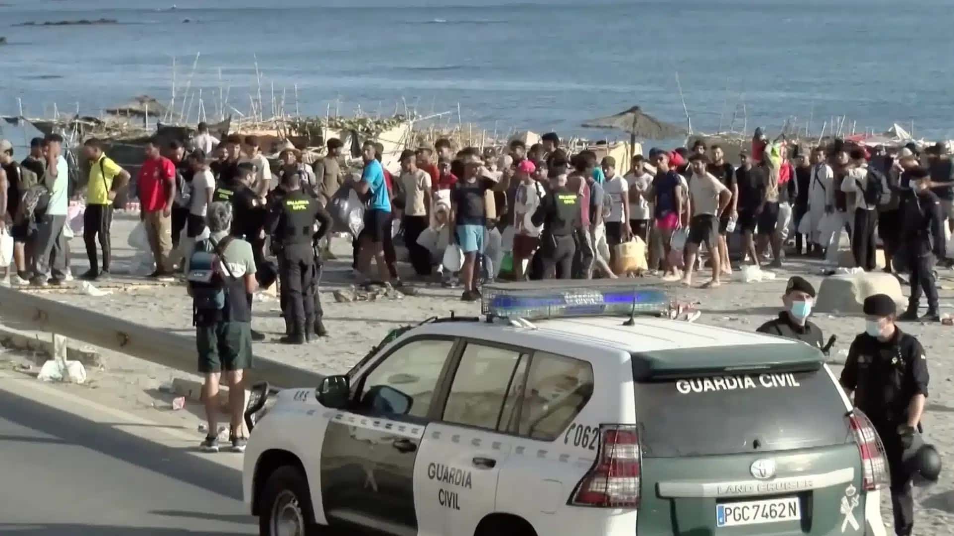 Dos mais de 80.000 imigrantes que chegaram a Ceuta no final de julho, 5.000 ainda estão no enclave espanhol; na foto, imigrantes deixando a praia de El Trampolín | Reprodução/YouTube @Poder360 – 21.ago.2026