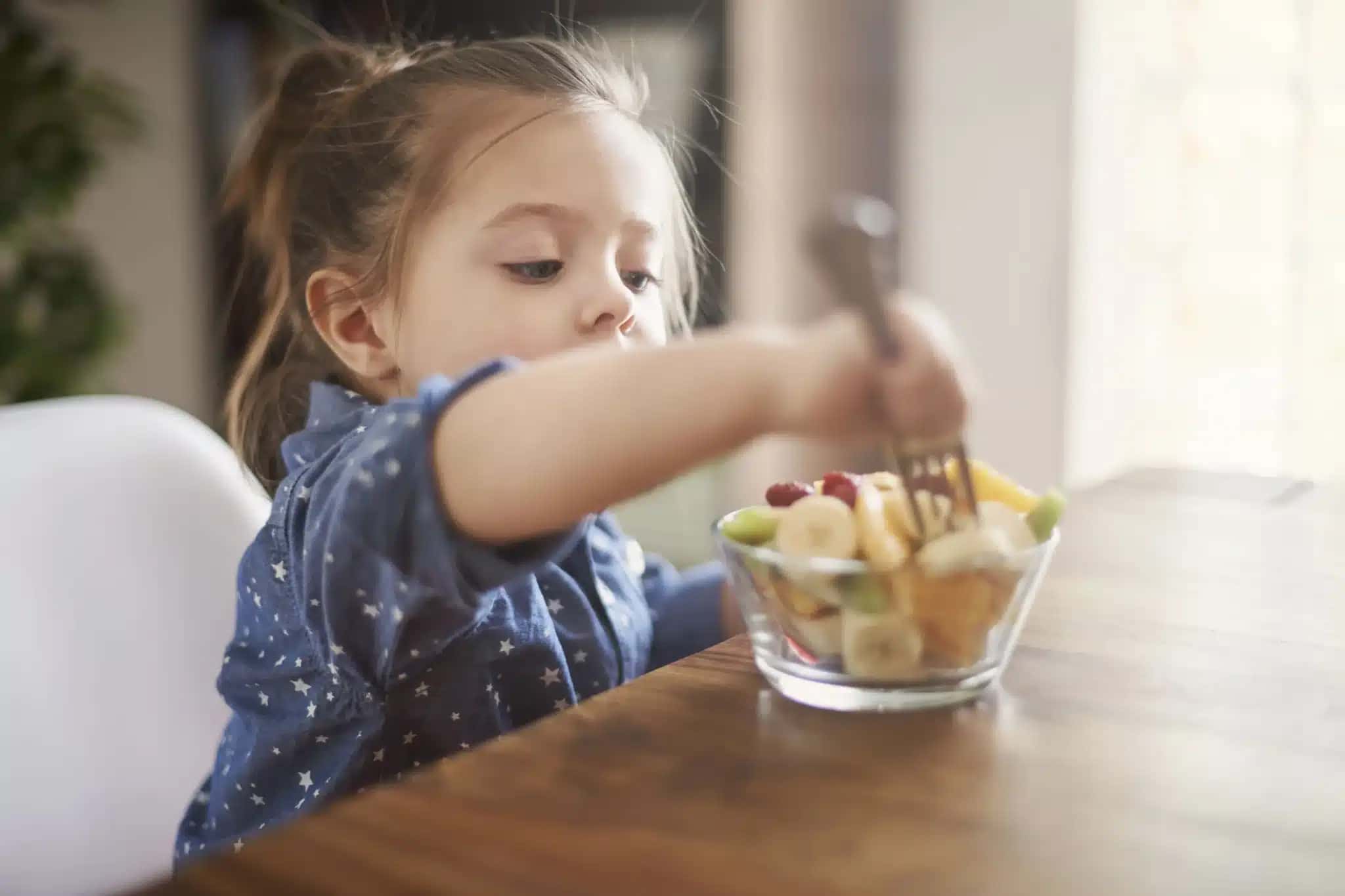 Criança comendo fruta