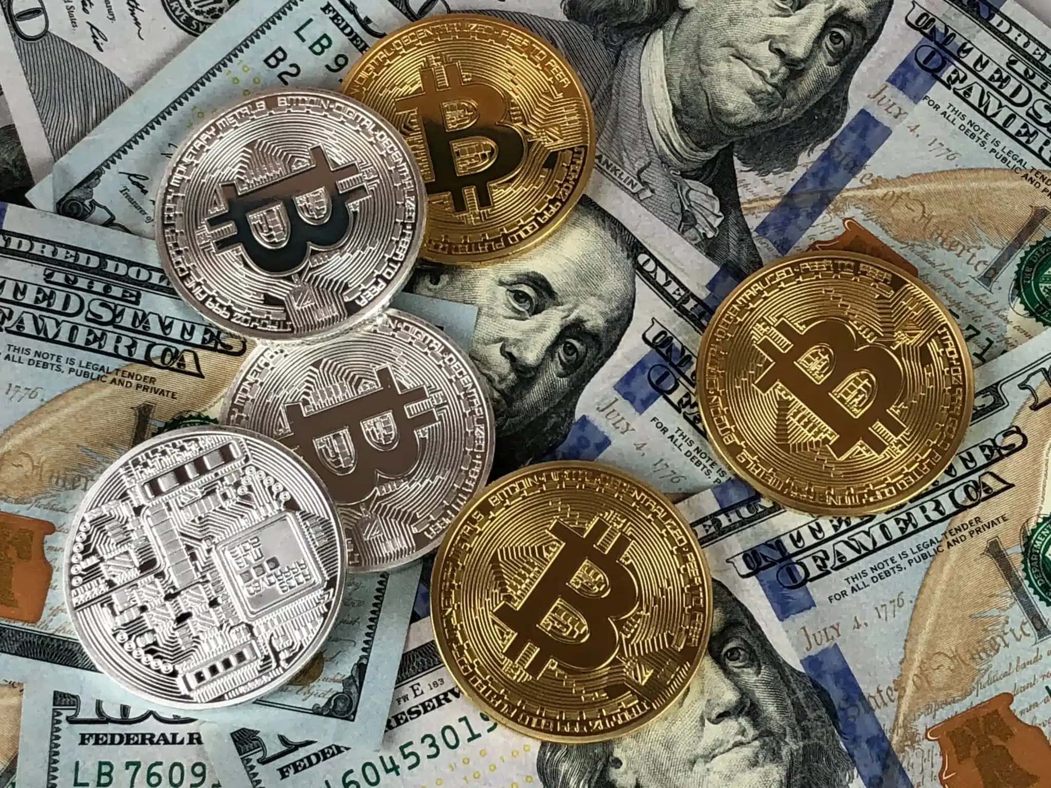 Representações físicas do bitcoins sobre notas de dólar