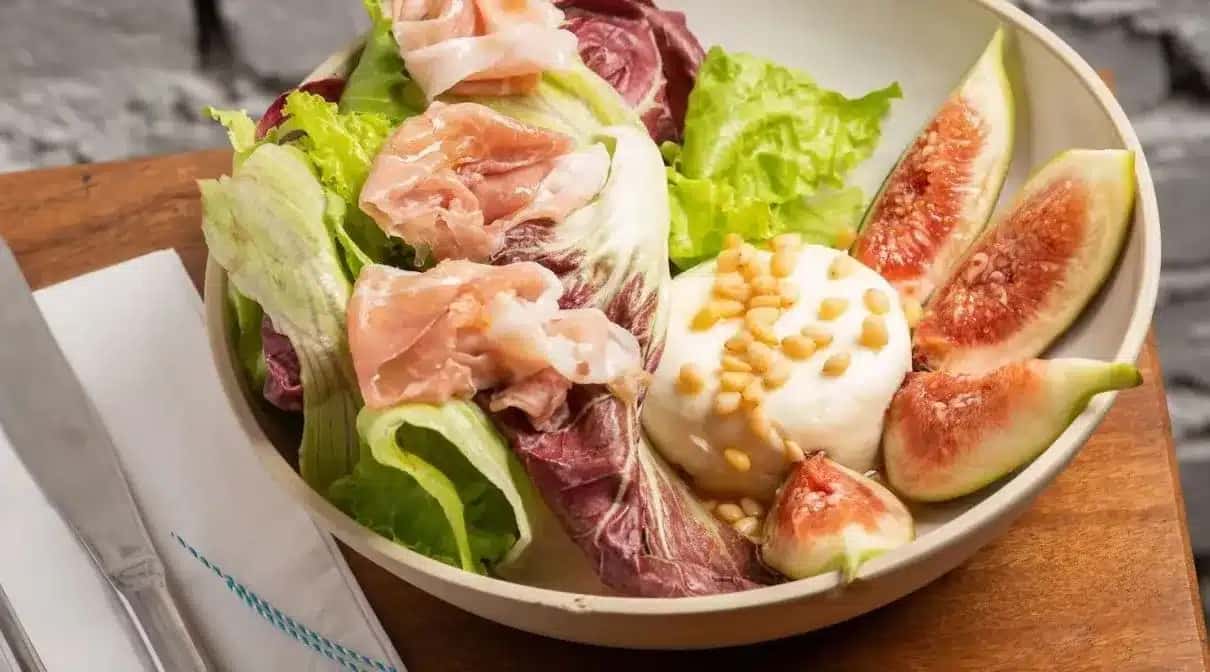 Salada feita com mix de folhas, queijo de cabra, presunto Parma, figo, mel orgânico e pinoli do restaurante grego Petros Greek Taverna