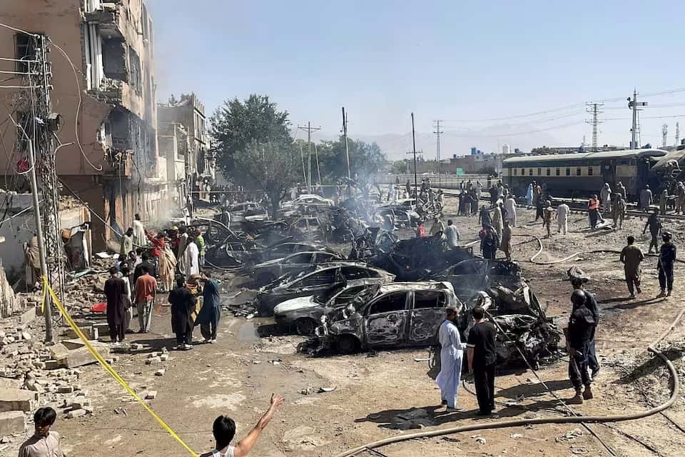 Pessoas e policiais se reúnem após uma explosão perto de uma linha ferroviária em Quetta, Paquistão, em 24 de maio de 2026.