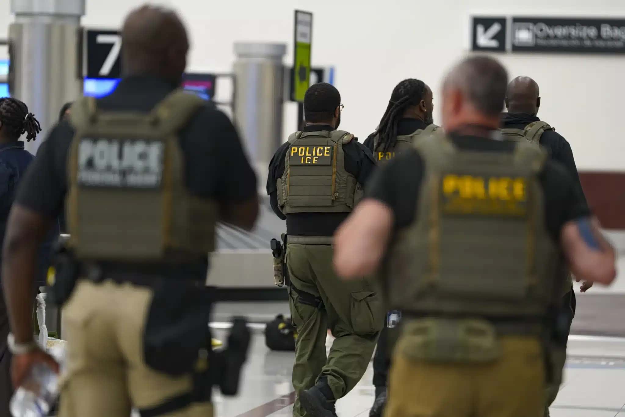 Grupo de agentes do ICE caminha pelo Aeroporto Internacional Hartsfield-Jackson em 25 de março de 2026, em Atlanta, Geórgia