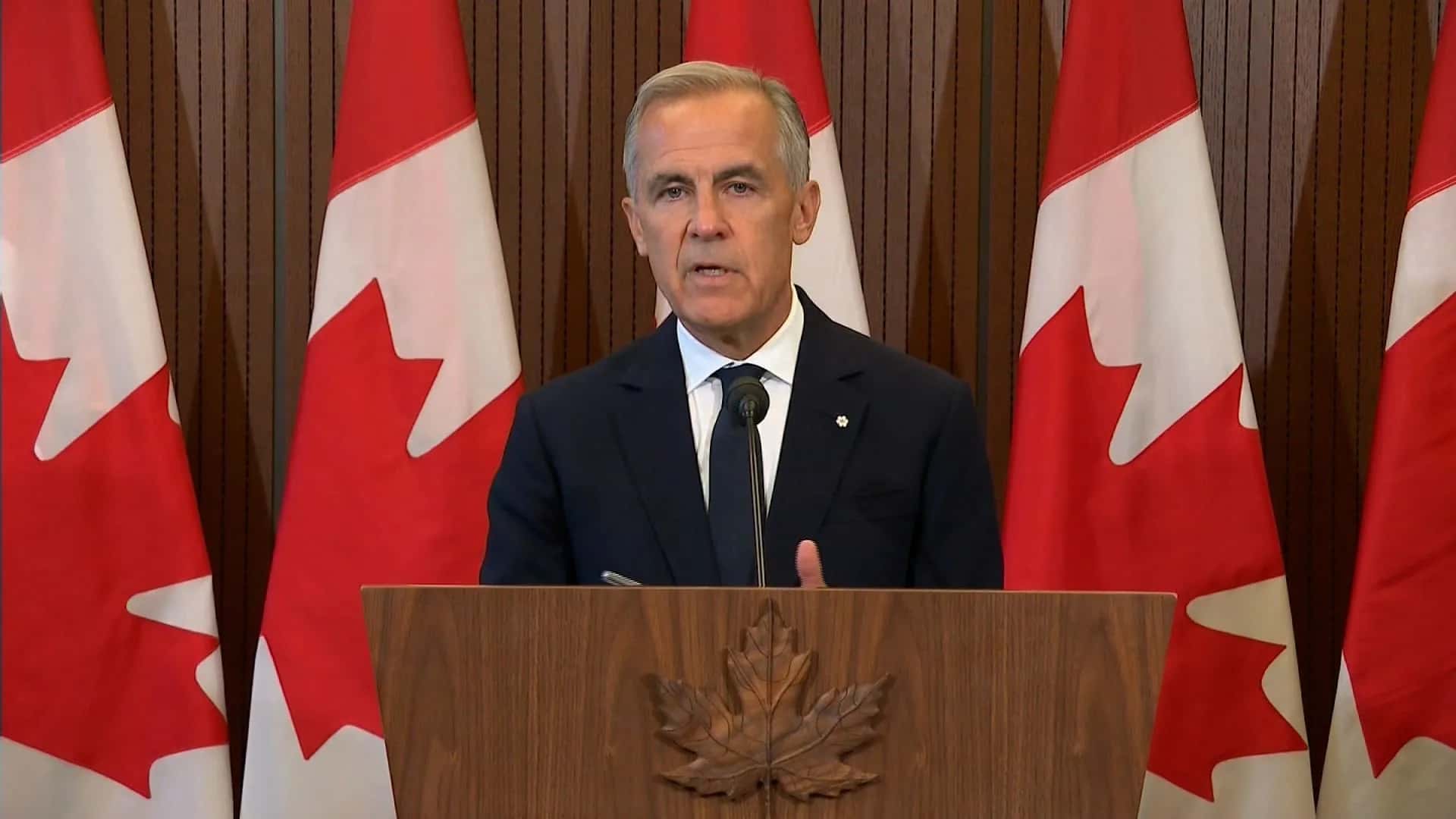 Mark Carney, líder do Canadá, com a bandeira do Canadá atrás