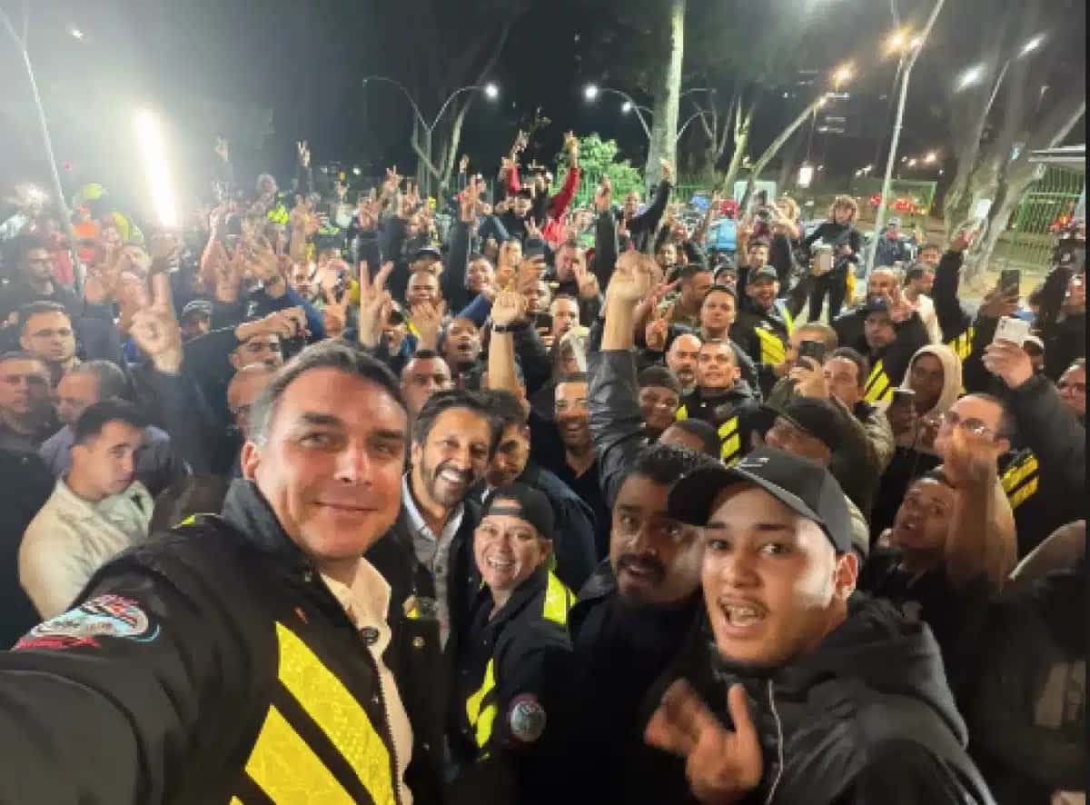 Flávio Bolsonaro (PL) posa com entregadores de aplicativo na capital paulista