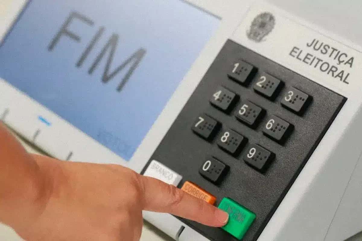 Close-up da mão de uma pessoa apertando o botão "confirma" na urna eletrônica | Foto: Reprodução/Superinteressante