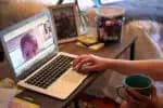 BROOKLINE, MA - MARCH 27: Ellie Lyons, an elementary school teacher, meets with her Natick first-grade students on Google Meet from her home in Brookline, MA on March 27, 2020. She has converted the backdrop of the bedroom in her Brookline apartment into a makeshift first-grade classroom to make her students more comfortable. Suburban schools are converting to online education as rapidly as possible as some parents demand more formalized schooling amid the shutdown. (Photo by David L. Ryan/The Boston Globe via Getty Images)