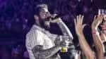 Post Malone desce do palco durante o momento de agradecimento com um fã na plateia