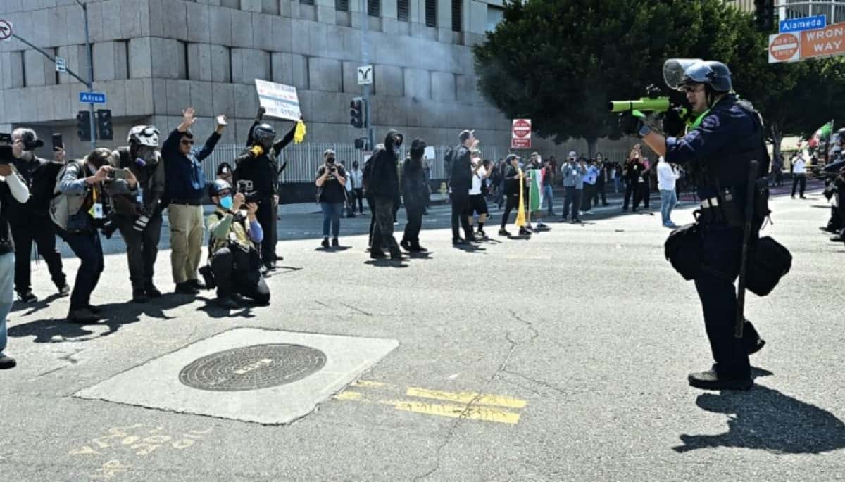 Law enforcement clashes with demonstrators outside the Metropolitan Detention Center, MDC, in downtown Los Angeles, California on June 8, 2025. US President Donald Trump deployed 2,000 troops on June 7 to handle escalating protests against immigration enforcement raids in the Los Angeles area, a move the state's governor termed "purposefully inflammatory." Federal agents clashed with angry crowds in a Los Angeles suburb as protests stretched into a second night Saturday, shooting flash-bang grenades and shutting part of a freeway amid raids on undocumented migrants, reports said. (Photo by Frederic J. Brown / AFP)