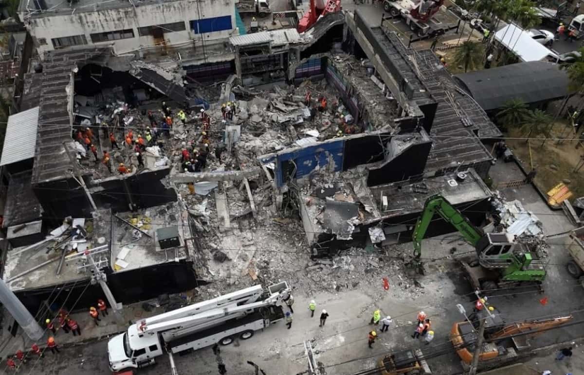 (FILES) Aerial view shows rescue teams working at the Jet Set nightclub a day after the collapse of its roof in Santo Domingo on April 9, 2025. Two owners of the Dominican Republic nightclub that collapsed in April, killing more than 230 revelers, were arrested on June 12, 2025, his lawyer told AFP. The prosecutor's office said in a statement that Antonio and Maribel Espaillat, who appeared earlier at the headquarters of the Attorney General's Office (PGR) were charged with involuntary manslaughter. (Photo by Alfred DAVIES / AFP)