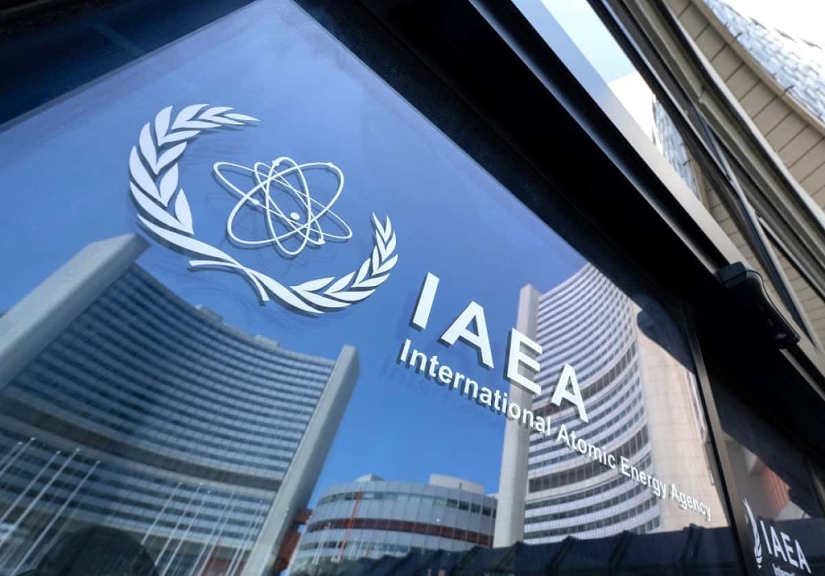 Buildings of the International Atomic Energy Agency (IAEA) headquarters reflect in doors with the agency's logo during the IAEAs Board of Governors meeting in Vienna, Austria on June 13, 2025, where the IAEAs head Rafael Grossi briefed board members following Israeli strikes on Iran, including on the Natanz uranium enrichment facility. (Photo by Joe Klamar / AFP)