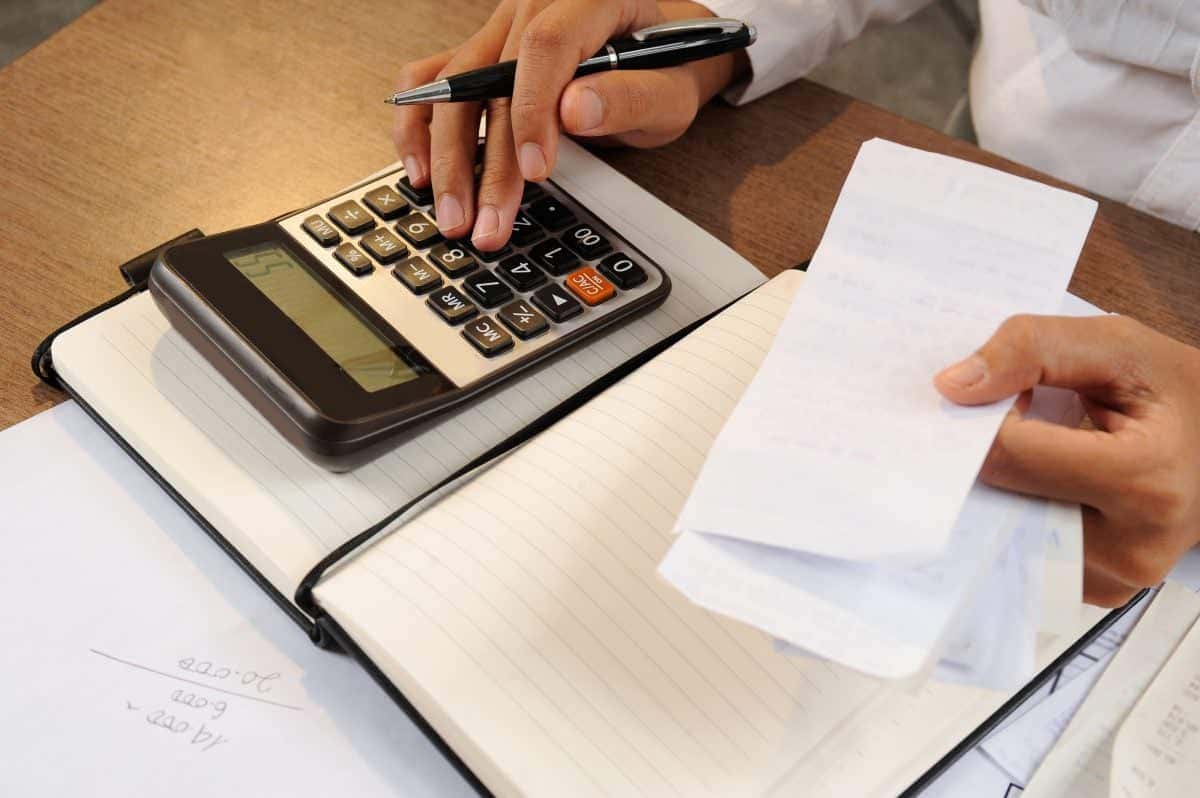 closeup-de-mulher-calculando-contas-ligado-calculadora-1