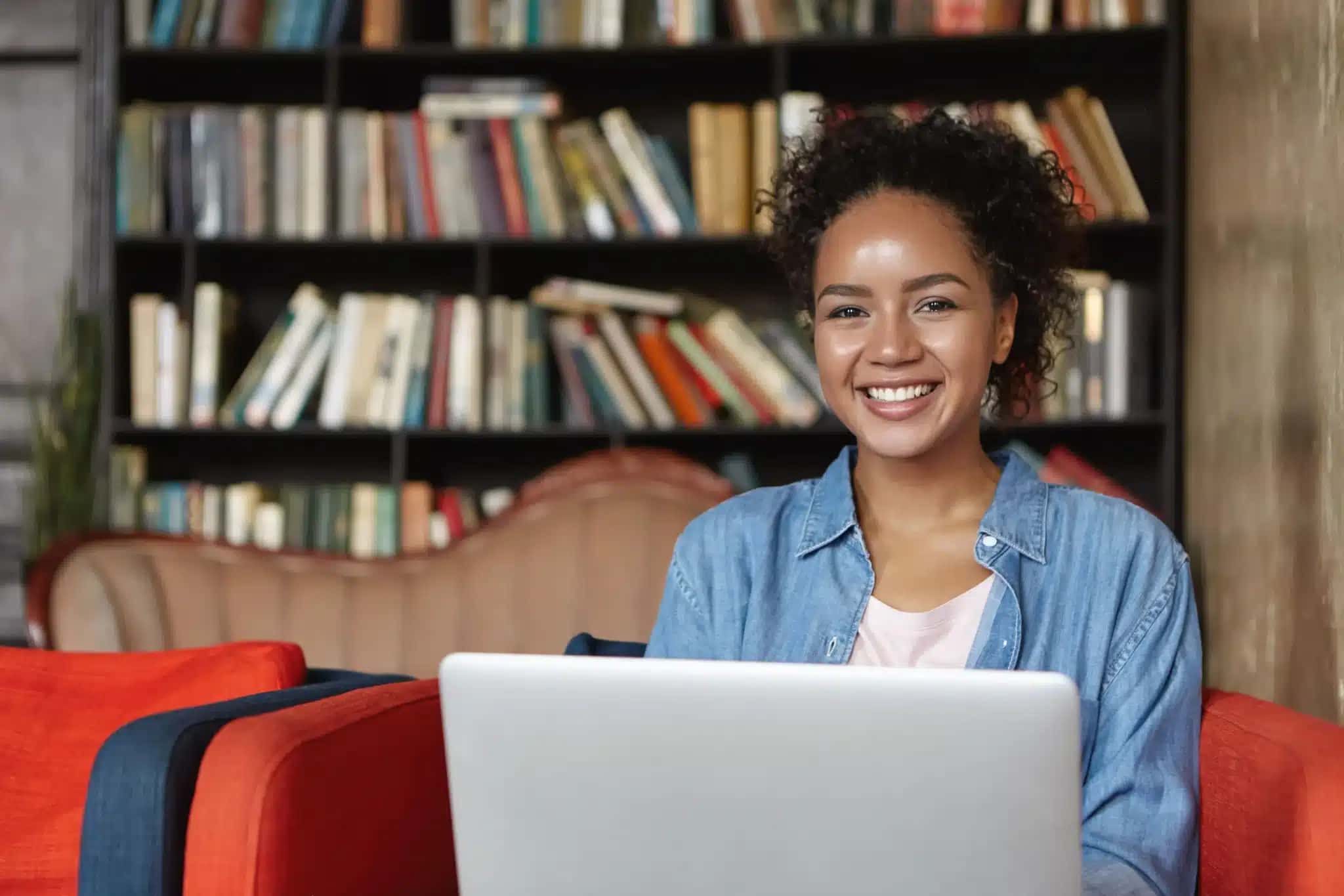 mulher-sentada-em-uma-biblioteca-com-seu-laptop