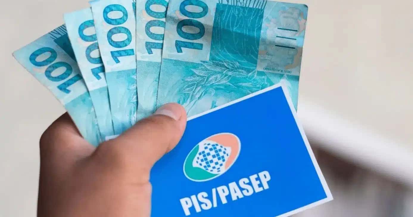 Homem-segurando-notas-de-cem-reais-e-cartao-do-PISPasep