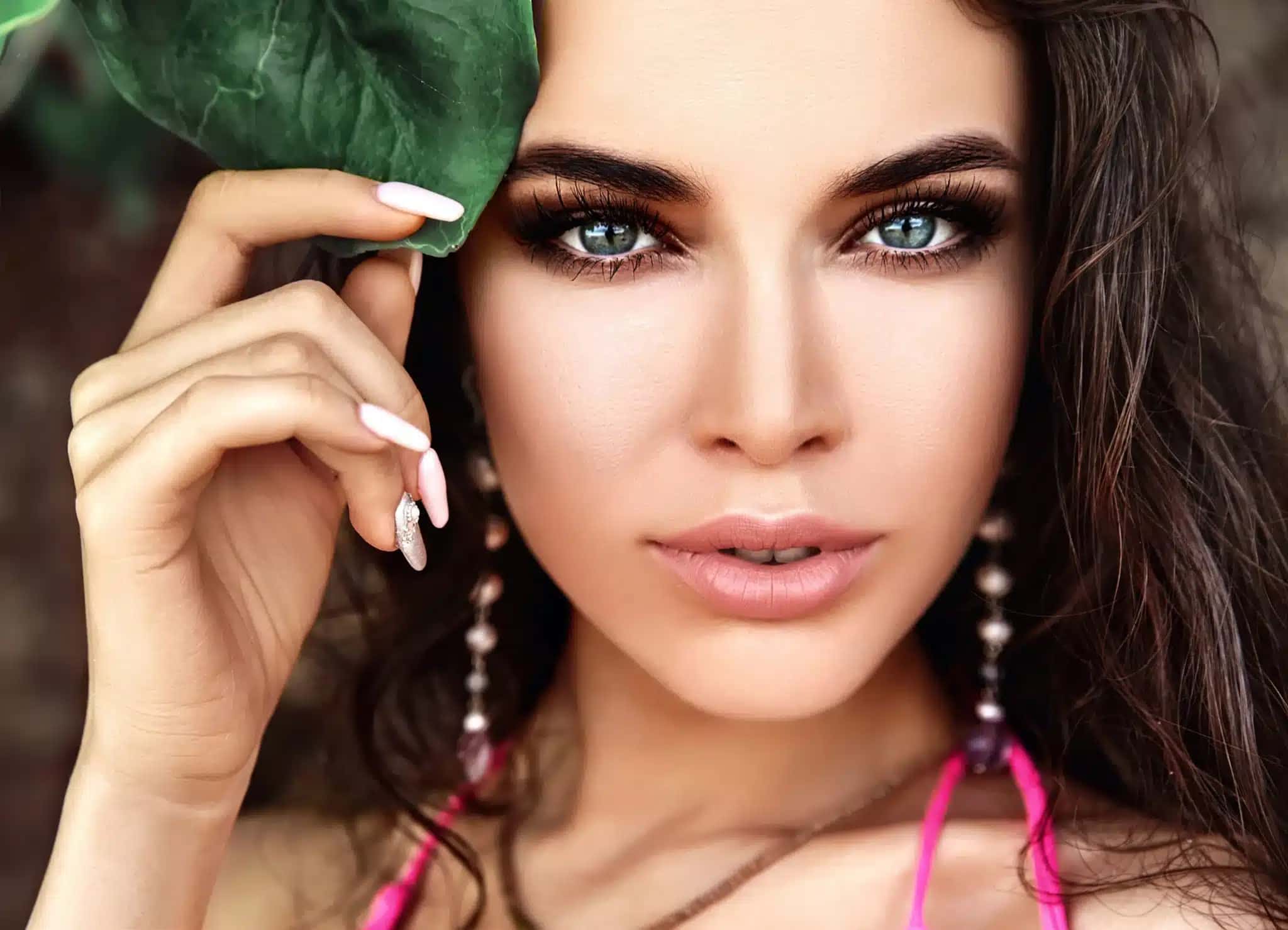 portrait-beautiful-caucasian-woman-model-with-dark-long-hair-pink-swimsuit-touching-green-tropical-leaf