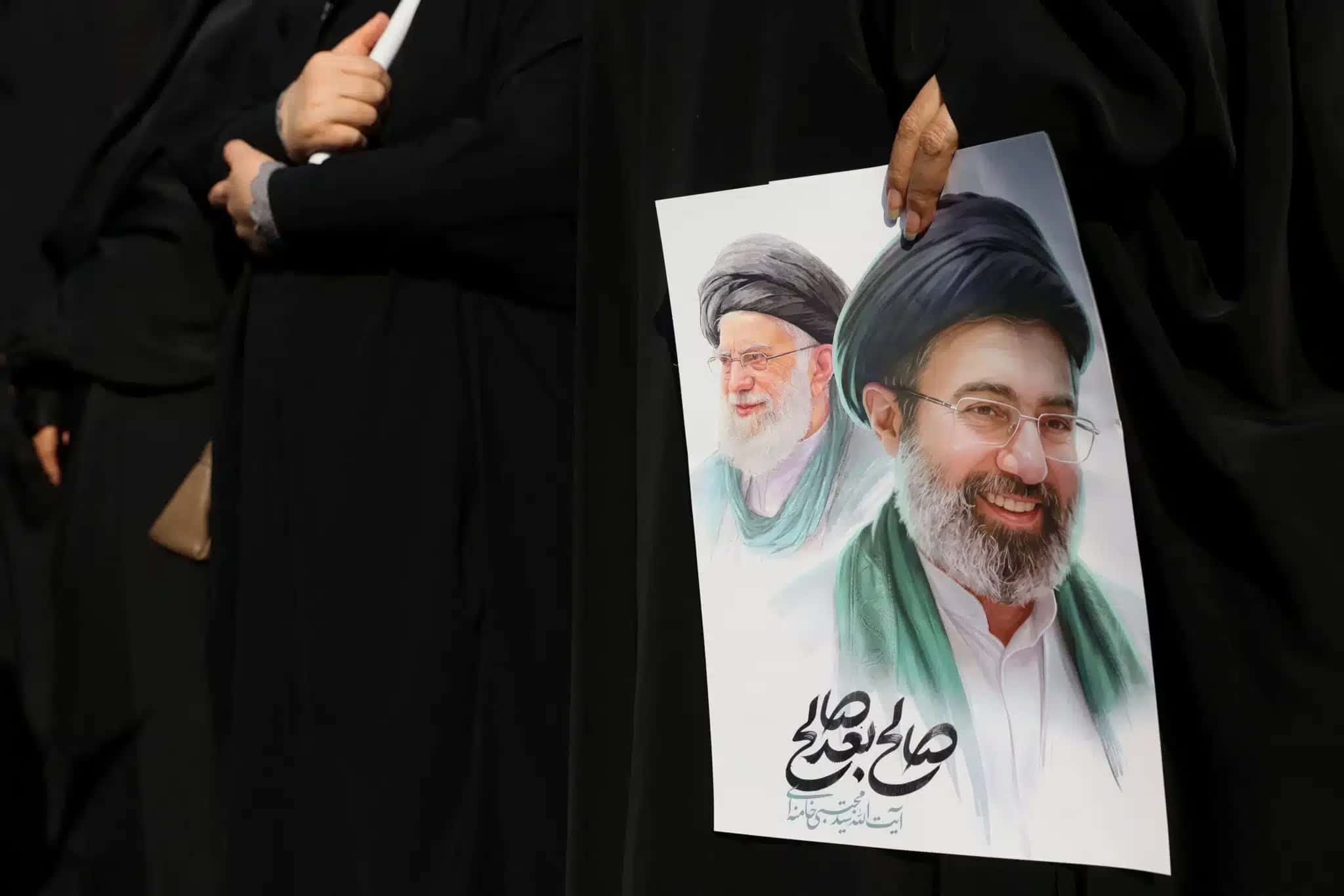 Mulher-segura-imagem-do-novo-lider-supremo-do-Ira-Mojtaba-Khamenei-e-do-lider-anterior-o-aiatola-Ali-Khamenei-durante-cerimonia-funebre-para-comandantes-militares-iranianos