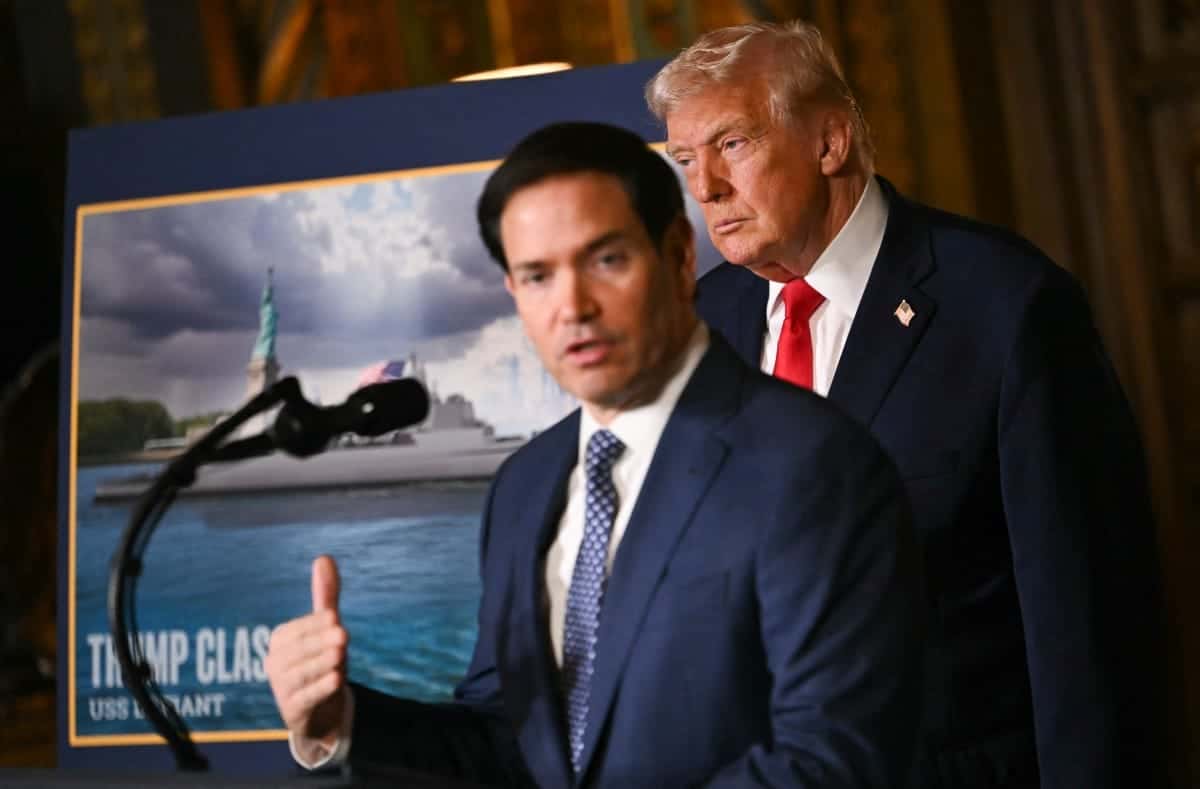 US President Donald Trump looks on as US Secretary of State Marco Rubio speaks about the US Navys new Golden Fleet initiative, unveiling a new class of warships, at Mar-a-Lago in Palm Beach, Florida, on December 22, 2025. President Donald Trump on December 22 announced a new class of heavily armed warships that will be named after himself -- an honor usually reserved for US leaders who have left office. Two of the Trump-class ships will be built initially but that number could grow substantially in the future, according to the president, who said they will be "some of the most lethal surface warfare ships" and "the largest battleship in the history of our country." Trump made the announcement at his Mar-a-Lago residence in Florida alongside Pentagon chief Pete Hegseth, Secretary of State Marco Rubio and Navy Secretary John Phelan, with images of the planned high-tech vessels on stands nearby. (Photo by ANDREW CABALLERO-REYNOLDS / AFP)