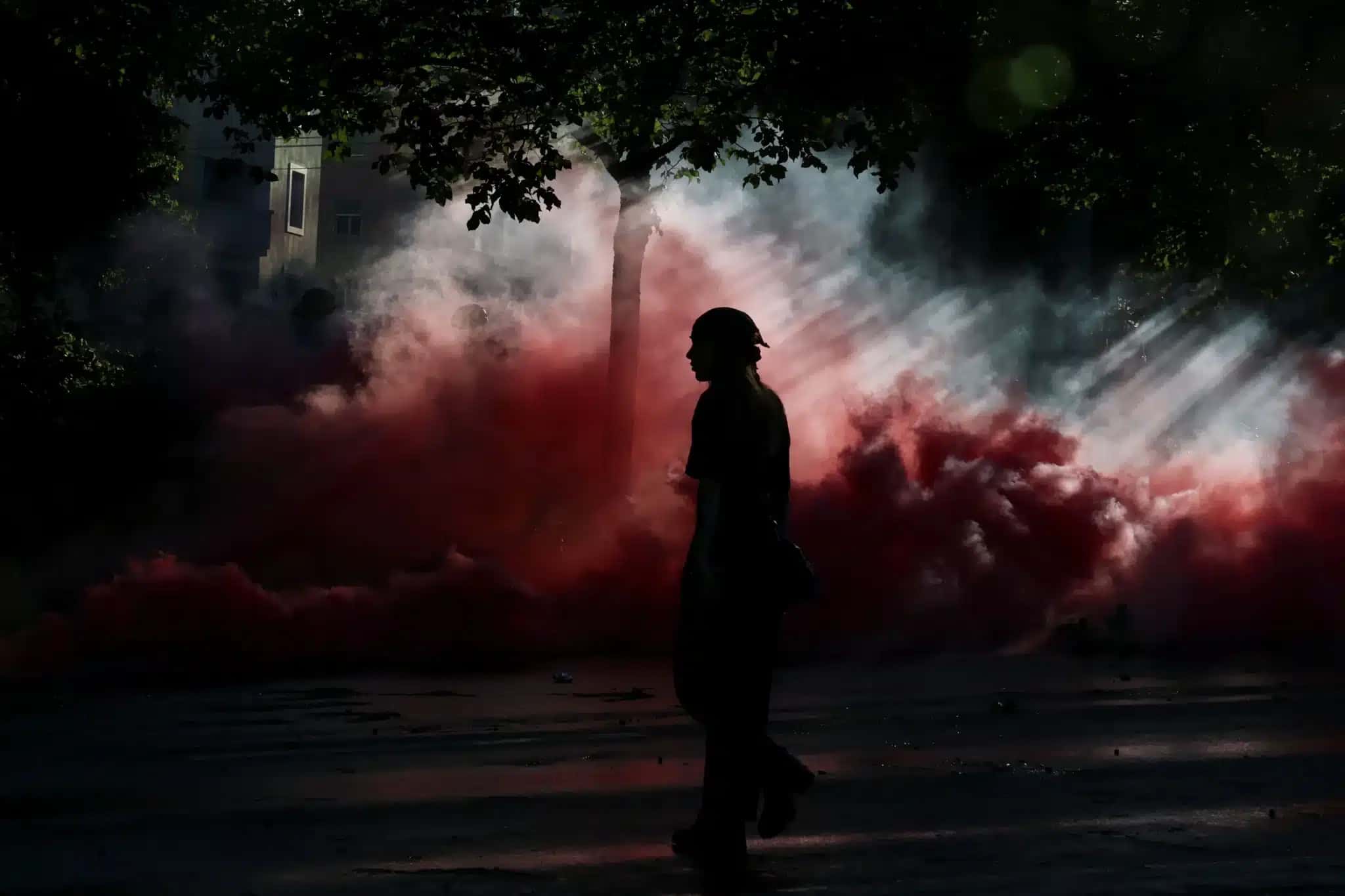 Pessoa-caminha-em-meio-a-nuvens-de-fumaca-durante-protesto-em-Genebra-contra-a-proxima-cupula-do-G7