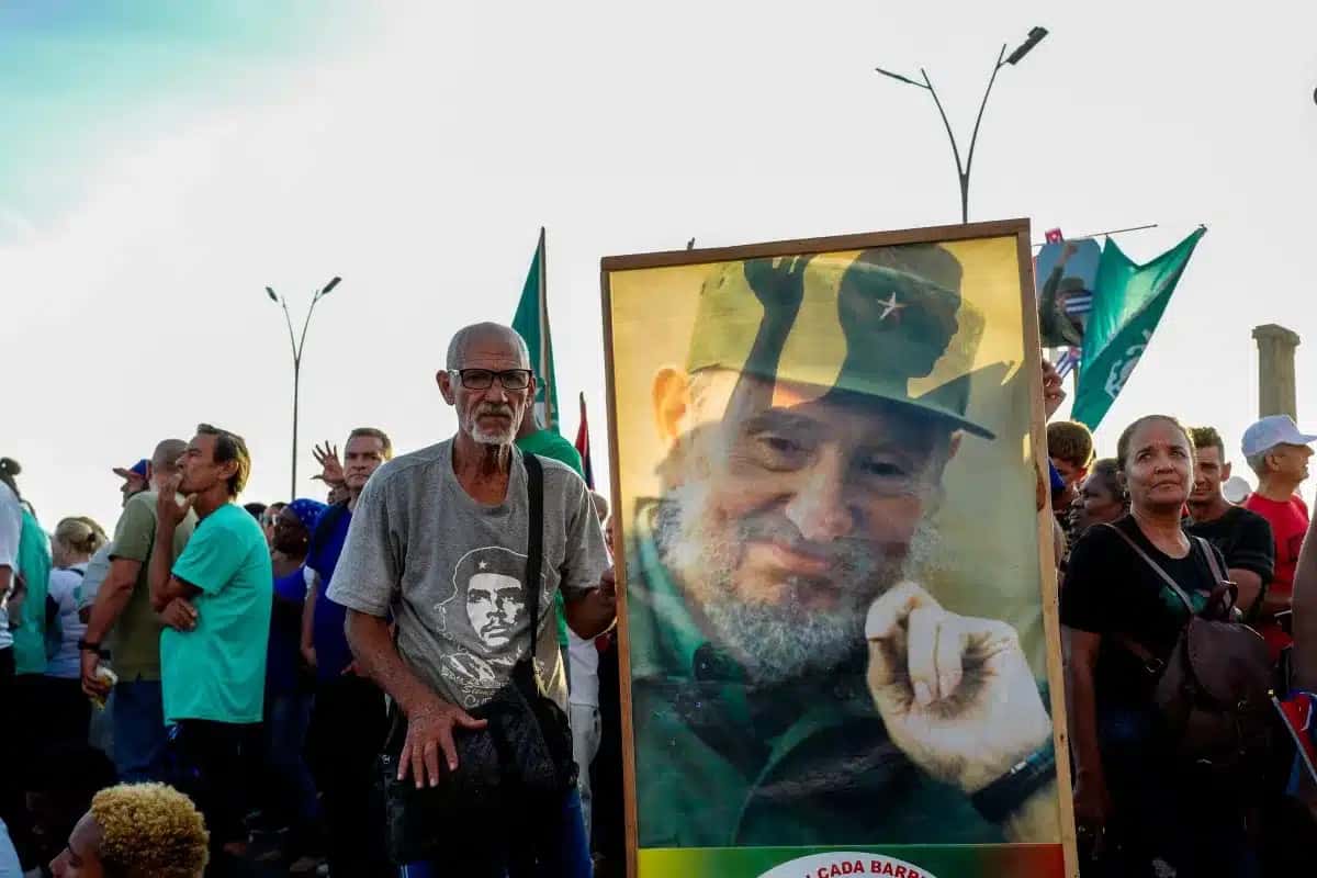 Homem segura cartaz com rosto de Fidel Castro em marcha do 1º de Maio