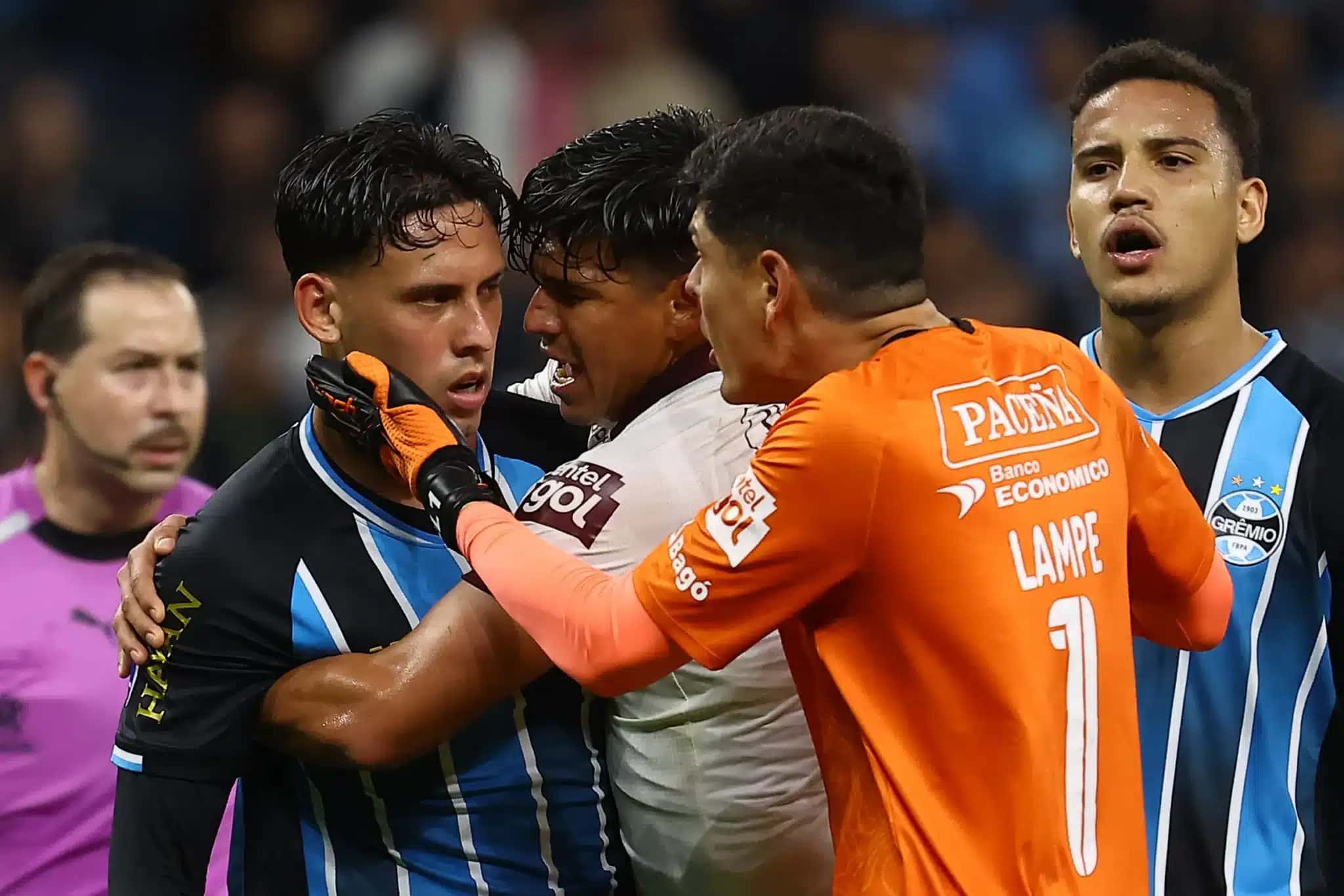 Zagueiro do Grêmio, Gustavo Martins (nº 06), e o zagueiro argentino do Bolívar, Santiago (nº 05), reagem depois que o árbitro chileno Piero Maza aplica cartões vermelhos ao meio-campista do Bolívar, Leonel Justiniano (nº 23, fora do enquadramento), e ao meio-campista peruano do Grêmio, Erick Noriega (nº 19, fora do enquadramento), durante o jogo de volta da Copa Sul-Americana