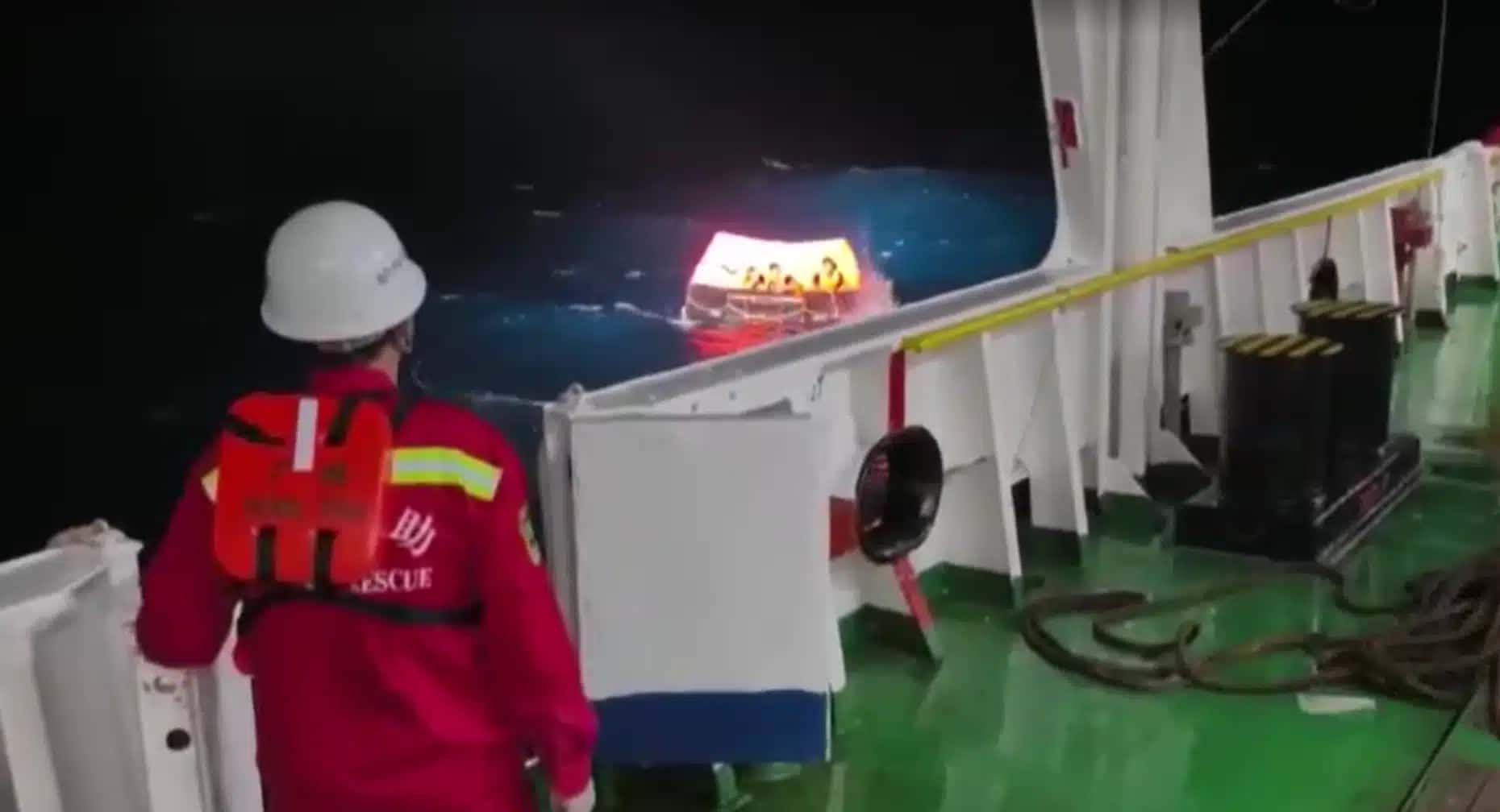 Pessoas são vistas em um bote salva-vidas e embarcando em um navio de resgate chinês após naufrágio