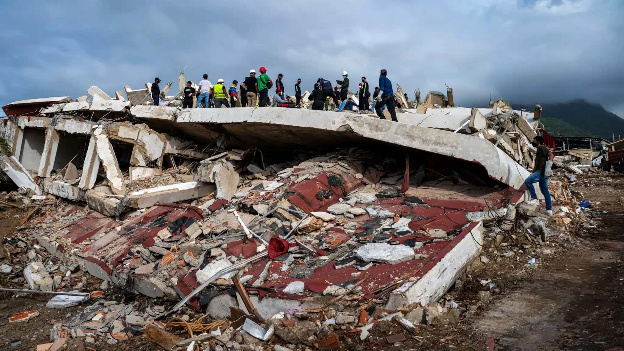 Voluntários e equipes de resgate ajudam a localizar sobreviventes em um prédio desabado em Caraballeda, no Estado de La Guaira, na Venezuela 30 de junho de 2026 MIGUEL MEDINA/Pool via REUTERS
