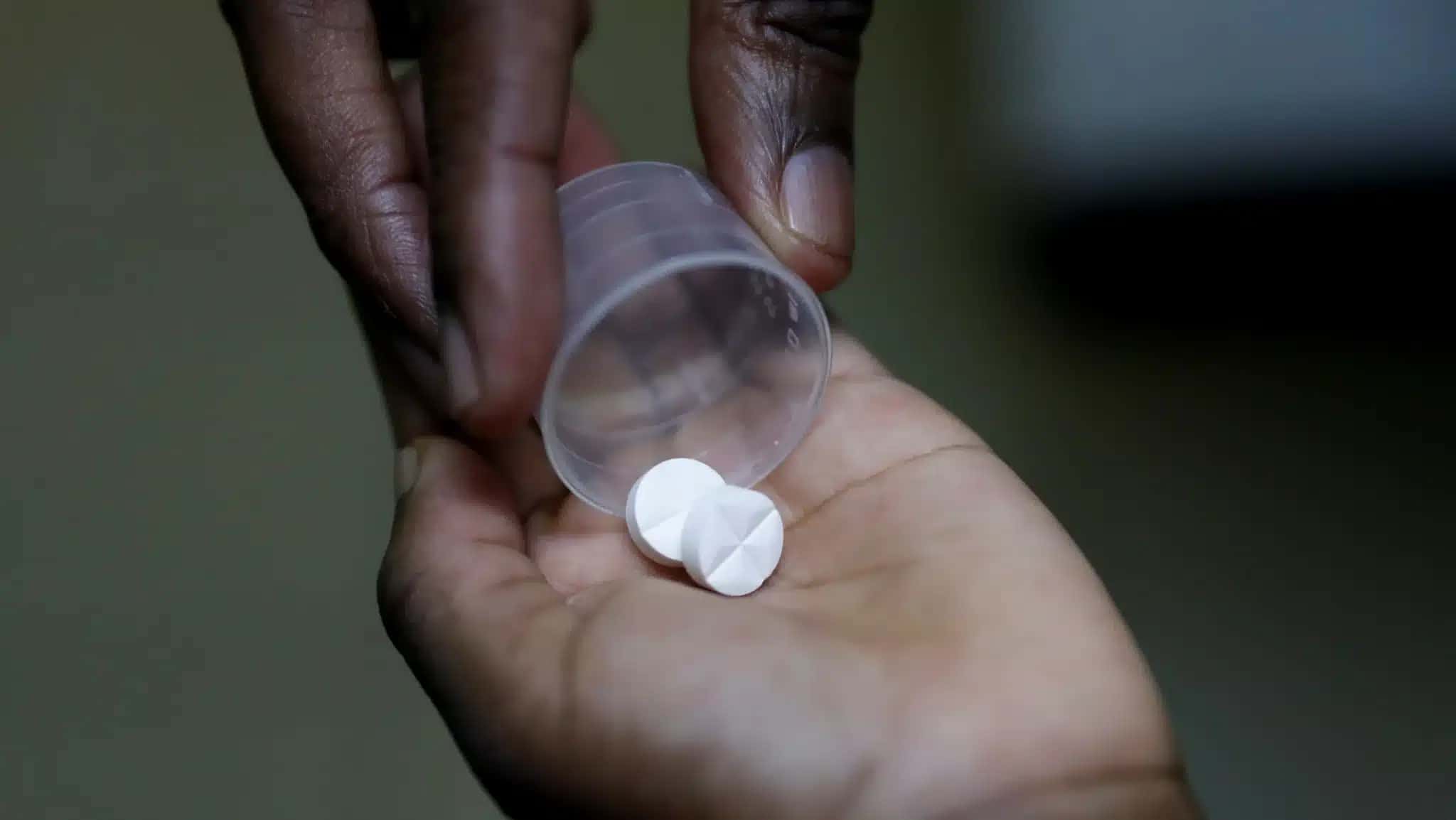 Enfermeira entrega medicamento ARV (antirretroviral), usado para impedir a replicação do HIV, a uma criança em orfanato no distrito de Karen, em Nairóbi, Quênia