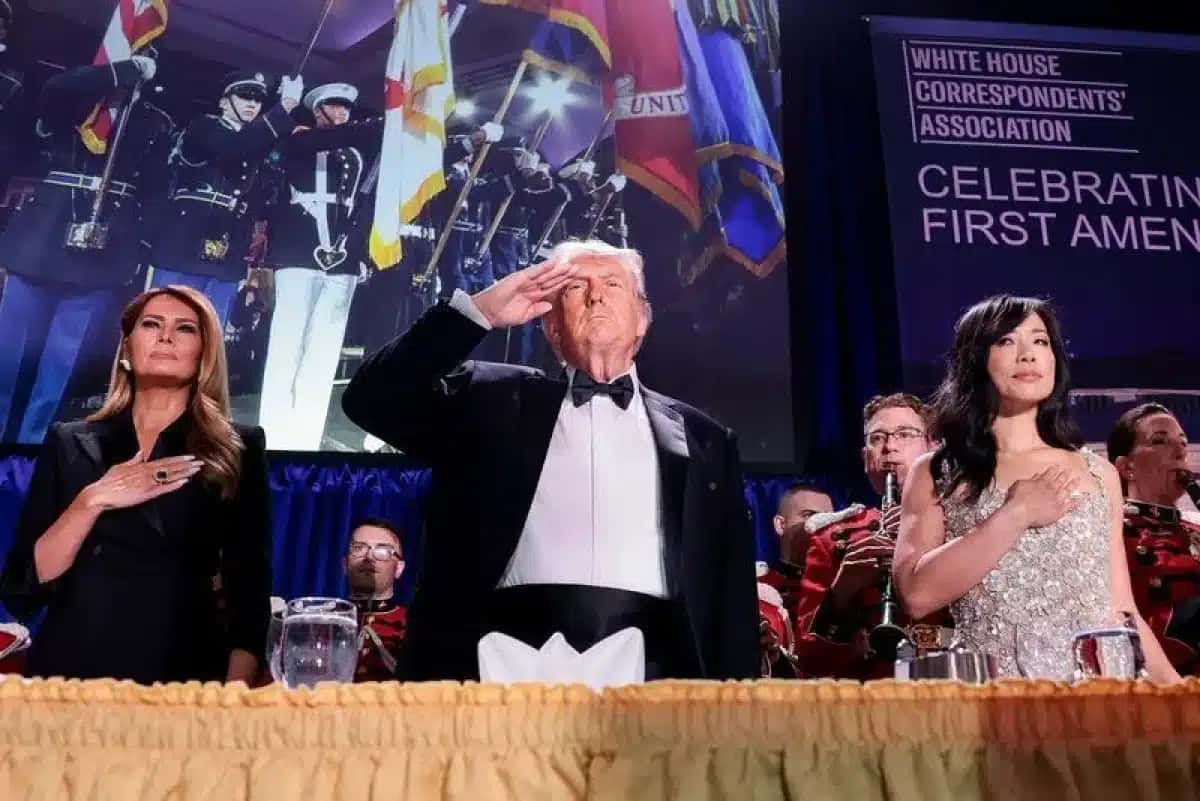 Presidente dos EUA, Donald Trump, acompanhado pela primeira-dama Melania Trump e pela correspondente sênior da CBS News na Casa Branca, Weijia Jiang, bate continência durante jantar anual da Associação de Correspondentes da Casa Branca, em Washington