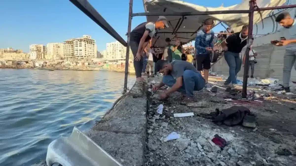 Palestinos inspecionam o local do ataque israelense que matou pelo menos seis pessoas perto do porto da cidade de Gaza