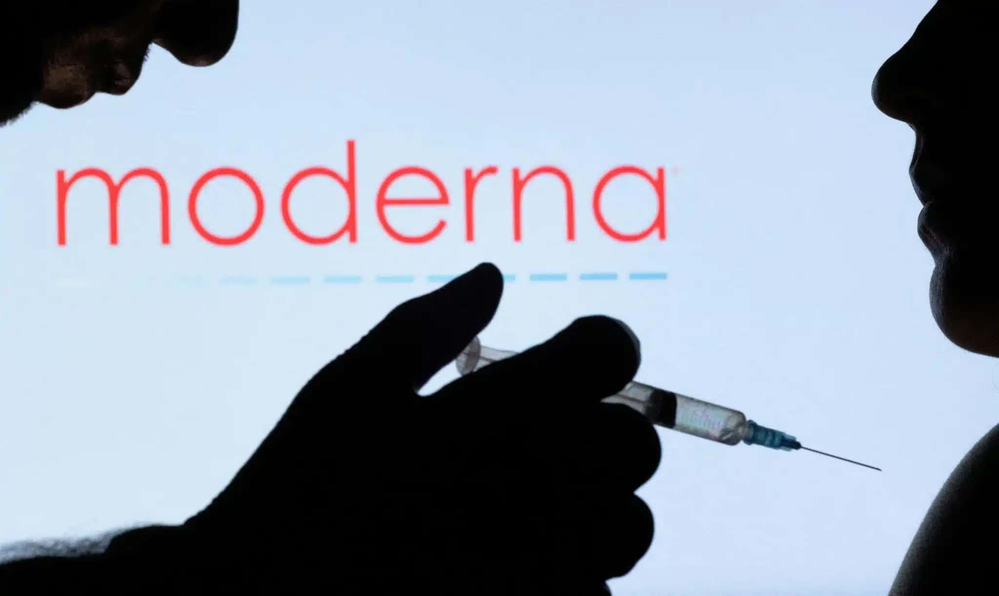 Pessoas posam com uma seringa com agulha em frente ao logotipo da Moderna exibido nesta ilustração tirada em 11 de dezembro de 2021. REUTERS/Dado Ruvic/Ilustração/Foto de arquivo