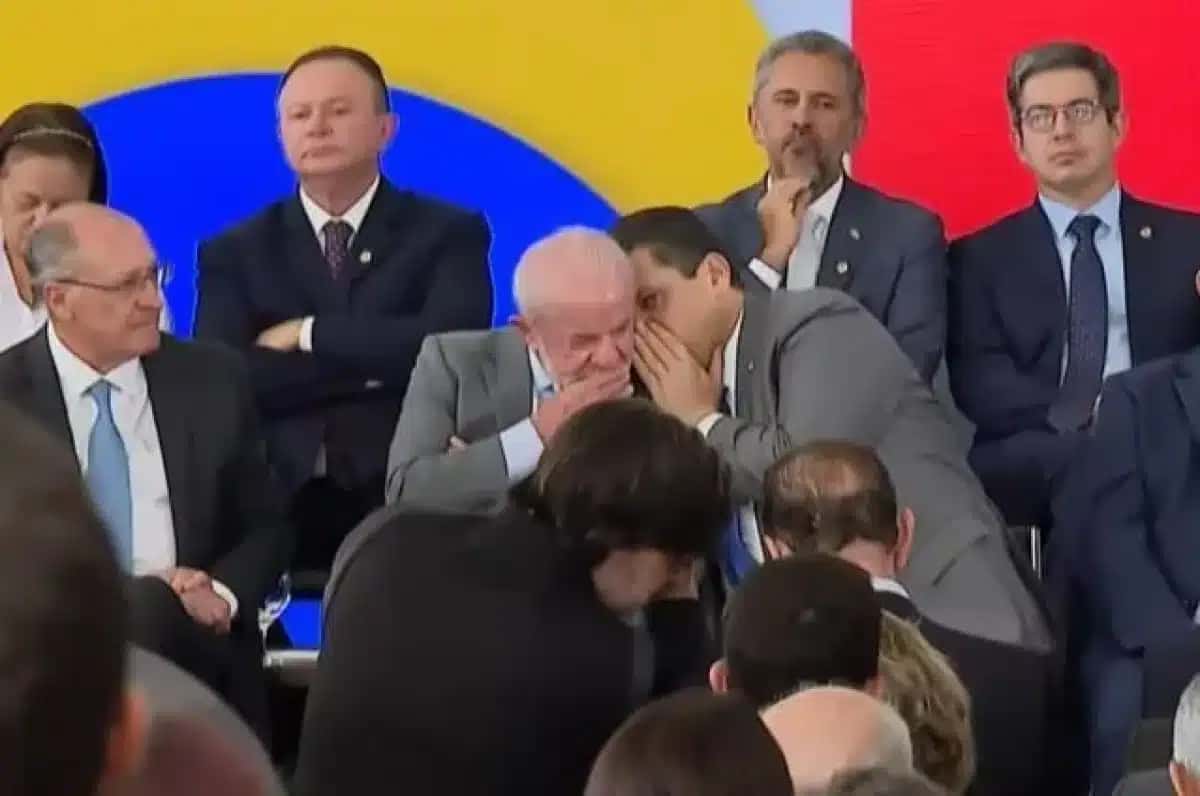 O presidente Luiz Inácio Lula da Silva (PT) conversa ao pé do ouvido com o presidente do Senado, Davi Alcolumbre (União-AP), durante evento no Palácio do Planalto