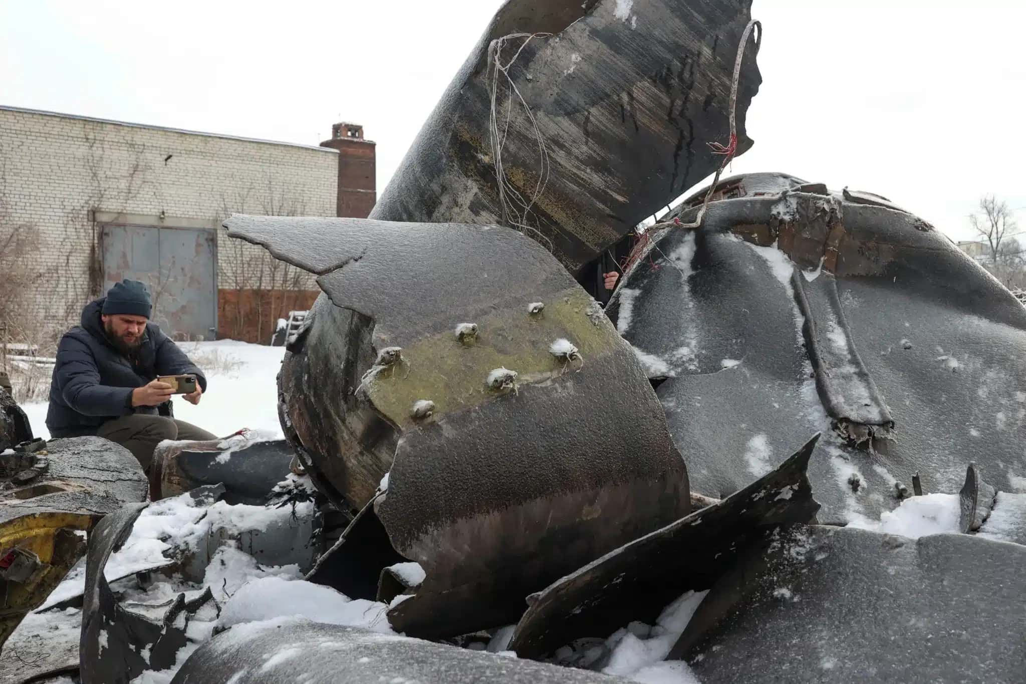 Um homem fotografa peças de um míssil não identificado, que as autoridades ucranianas acreditam ter sido fabricado na Coreia do Norte e utilizado em um ataque em Kharkiv 6 de janeiro de 2024