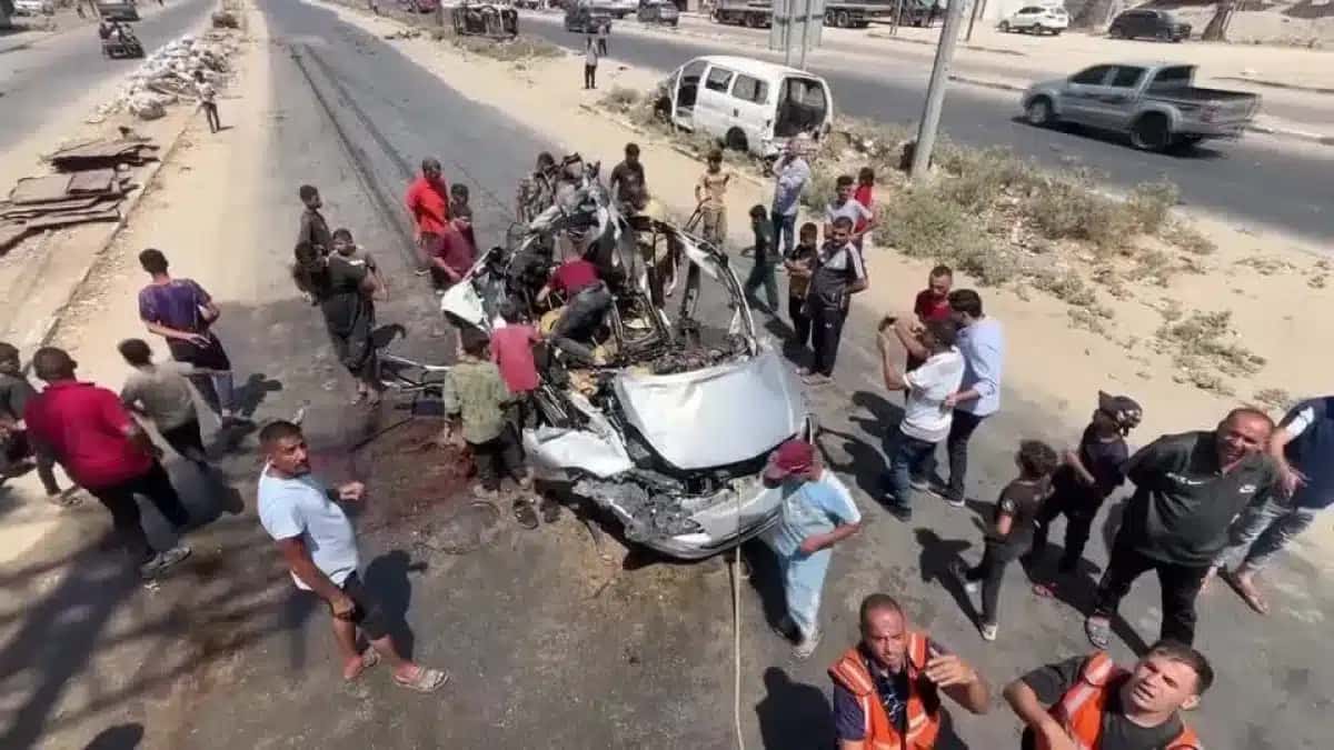Palestinos verificam as consequências do ataque israelense a um veículo em Deir al-Balah, na Faixa de Gaza