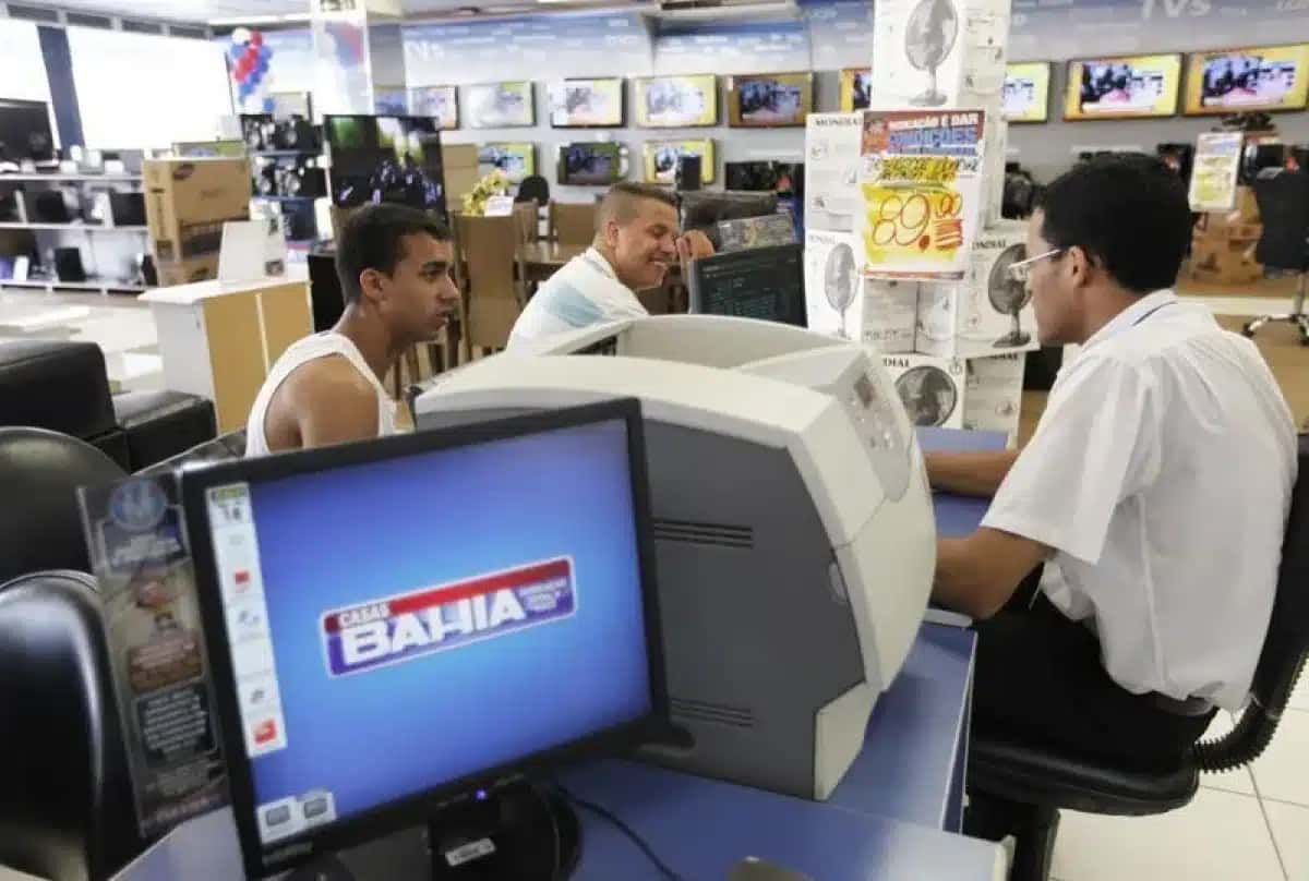 Consumidores conversam com funcionário da Casas Bahia em loja da rede em São Paulo