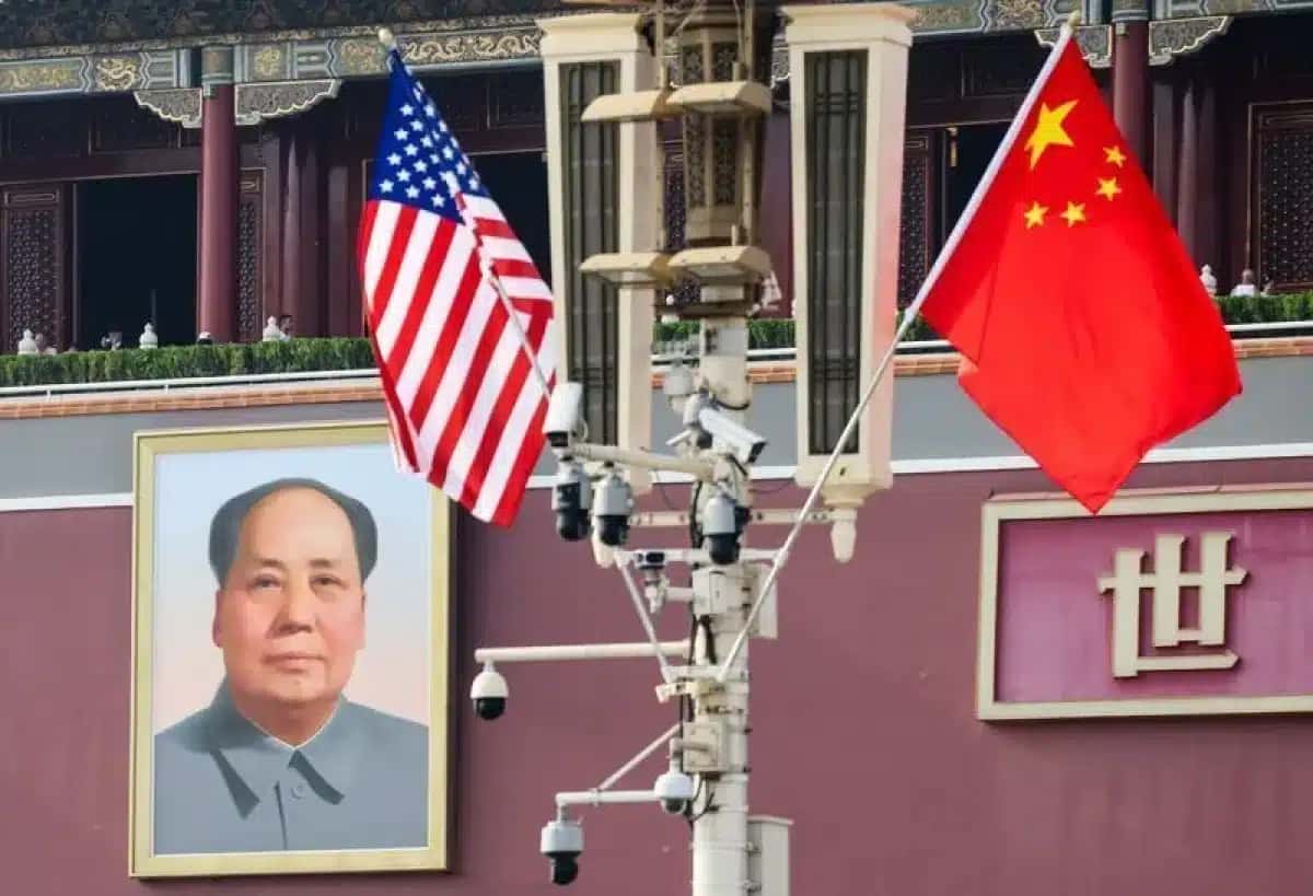 Bandeiras nacionais dos EUA e da China ao lado do retrato do falecido presidente chinês Mao Zedong, antes da visita do presidente dos EUA, Donald Trump, à China, em Pequim