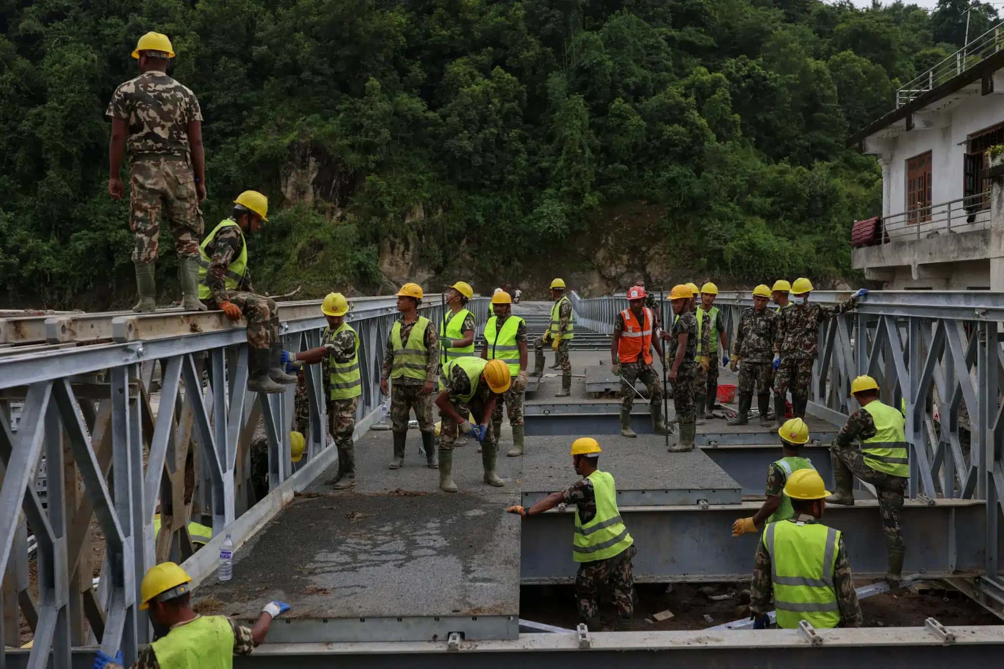 Militares do Exército do Nepal trabalham na construção de uma ponte de ferro sobre o rio Tadi, após enchentes repentinas fatais e um deslizamento de terra, em Devighat, distrito de Nuwakot, Nepal, em 7 de setembro de 2026