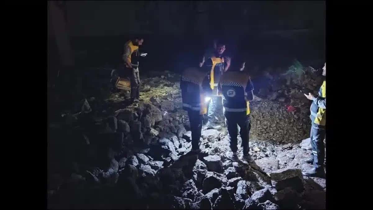 Equipes de emergência sírias realizam operações de busca e resgate em locais atingidos por ataques aéreos jordanianos na noite de segunda-feira (26).