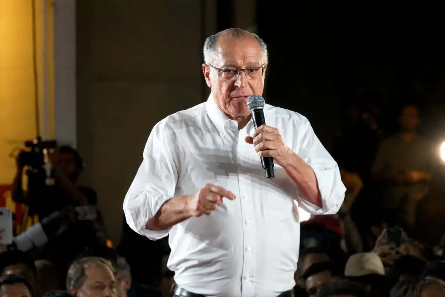 Fotografia de Geraldo Alckmin discursando com microfone na mão em um palco | Foto: Reprodução/Exame