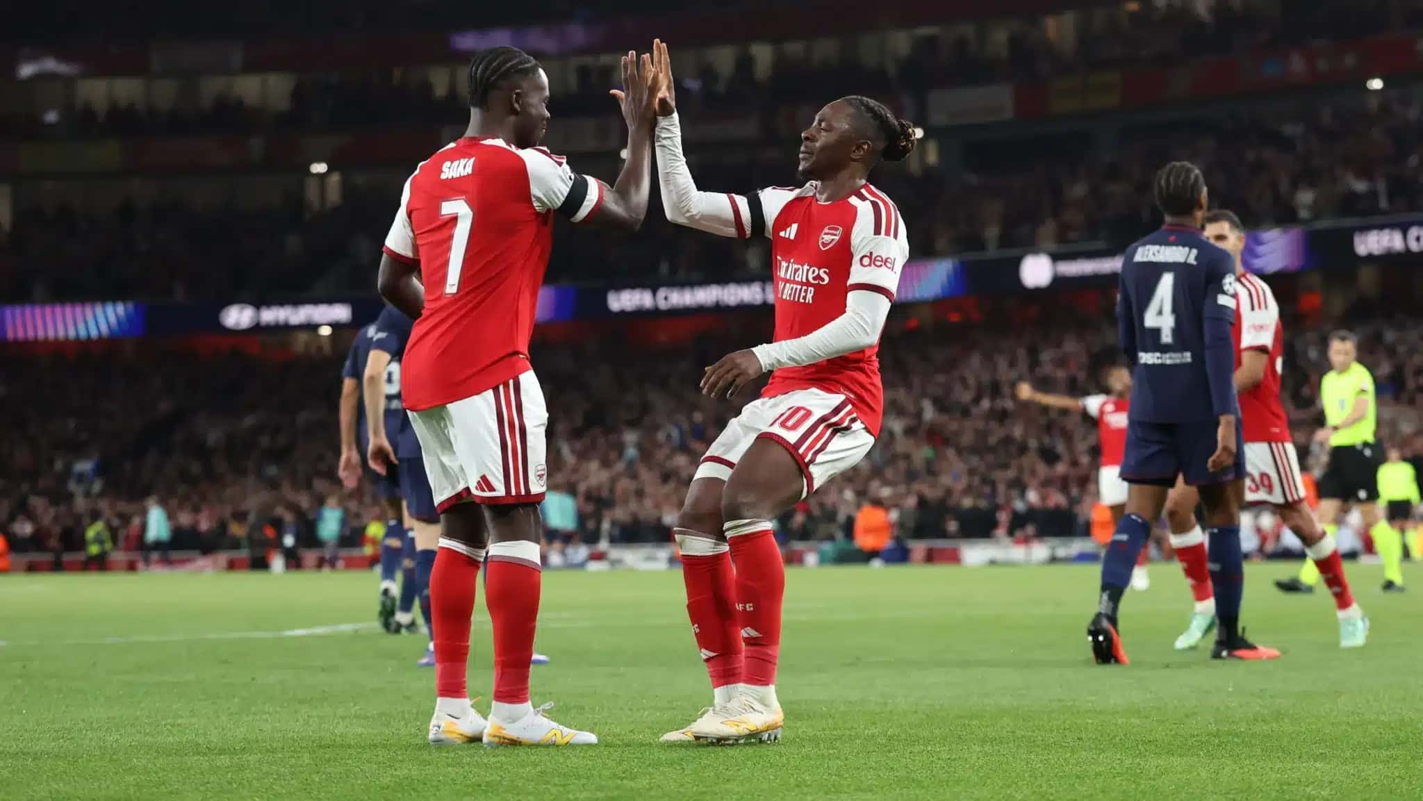 Saka e Eze, autores de gols do Arsenal contra o Lille pela Champions League, comemoram um deles.