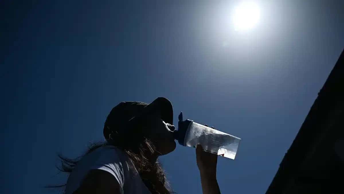 Mulher tenta se refrescar bebendo água durante uma onda de calor em Londres, Reino Unido, em 26 de maio de 2026.