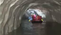 Socorristas do exército do Nepal usam botes para buscar trabalhadores em túnel inundado